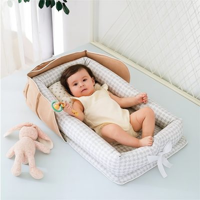 cocon bebe cana gris avec bébé couché jouant