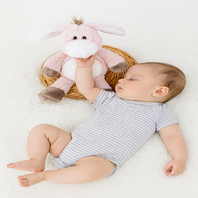 doudou bébé âne rose avec bébé dans son lit