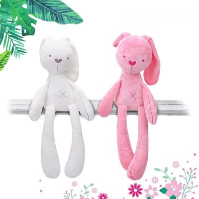doudou bébé fille pompon lapin rose et blanc présenté de façon assise