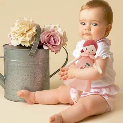 doudou bebe princesse bébé assis à cÎté de pot de fleur