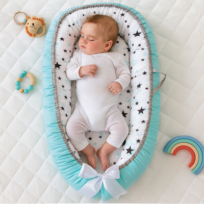 réducteur de lit bébé cocon d'or avec bébé endormi