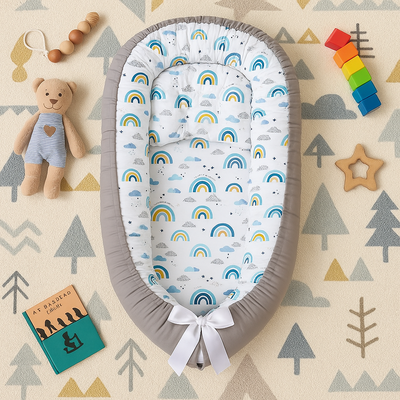 réducteur de lit bébé cocon d'or posé sur tapis de jeu