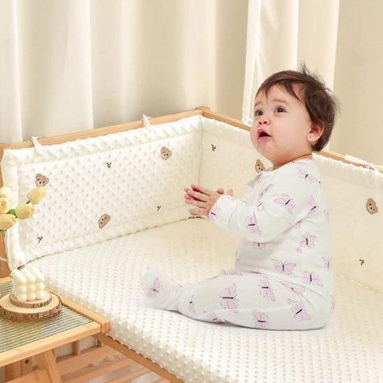 tour de lit bébé cocon douillet ourson avec bébé assis