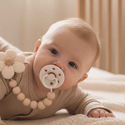 attache tetine jolie fleur bébé allongé