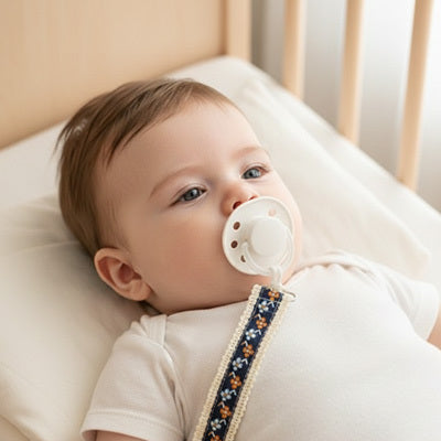 attache tetine pendentif bleu bébé allongé