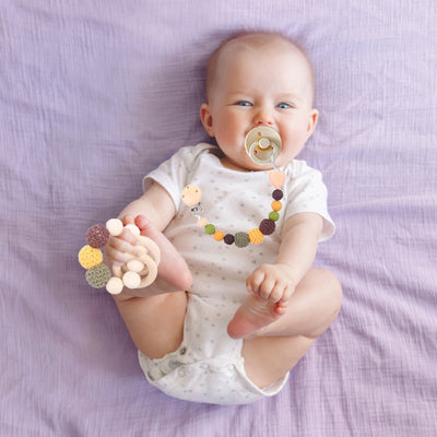 attache tétine perles jaune bébé allongé